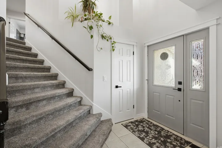 Entryway featuring a decorative glass front door, side panel, and a tiled floor