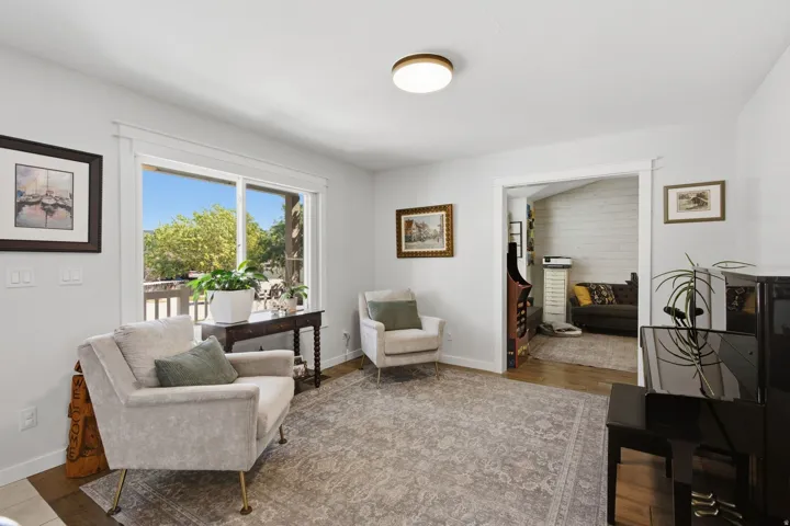 Recessed lighting, wood-finish flooring, sliding glass door, white trim, and an open doorway