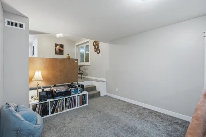 Multi-level room with carpet flooring, recessed lighting, and a window