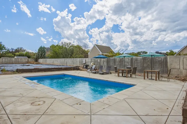 In-ground swimming pool with surrounding concrete decking