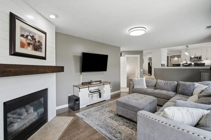 Living area with a modern fireplace, wood-finish flooring, recessed lighting, and an open concept layout