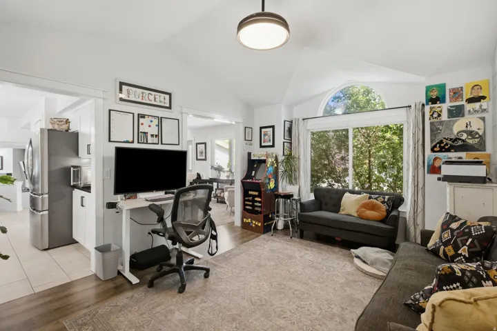 Vaulted ceiling featuring a large arched window above expansive windows