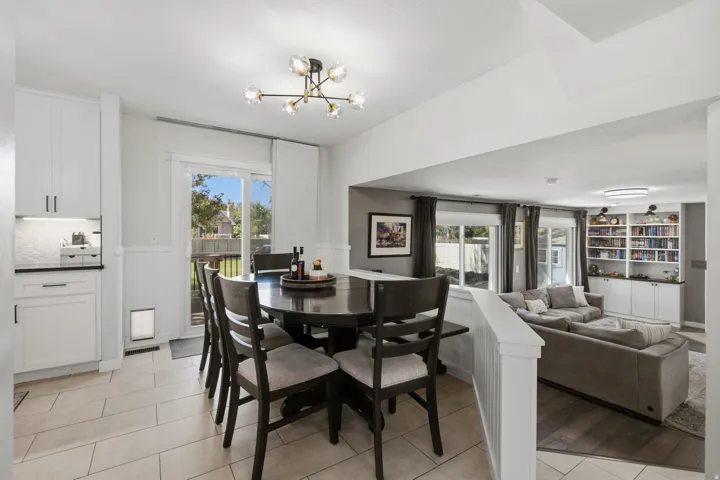 White shaker cabinetry with dark hardware, recessed lighting, tile flooring, and sliding glass door