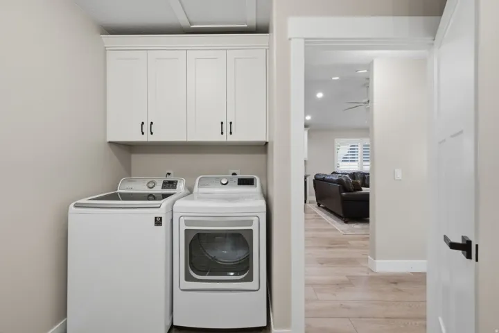 Built-in white cabinetry with black hardware, wood-finish flooring, and recessed ceiling lighting