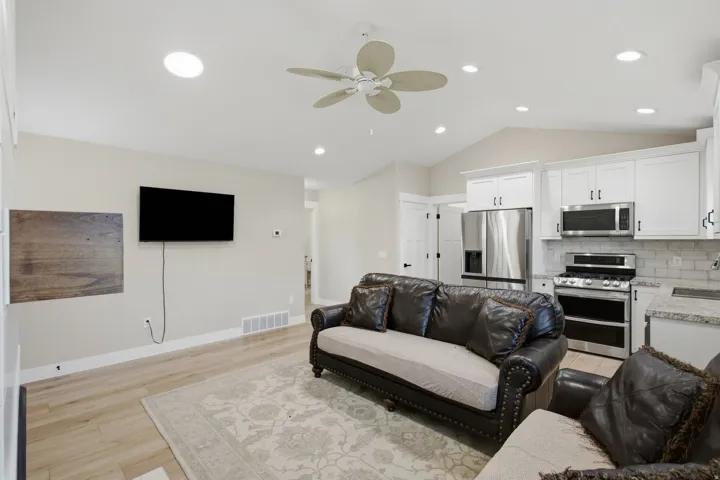Open-concept living space with vaulted ceilings, recessed lighting, and a ceiling fan