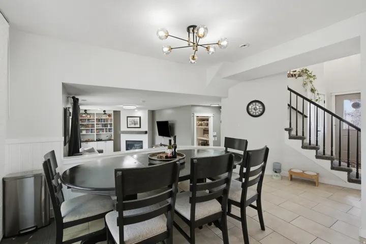 Open-concept main level featuring a modern sputnik chandelier, wainscoting, and tile flooring