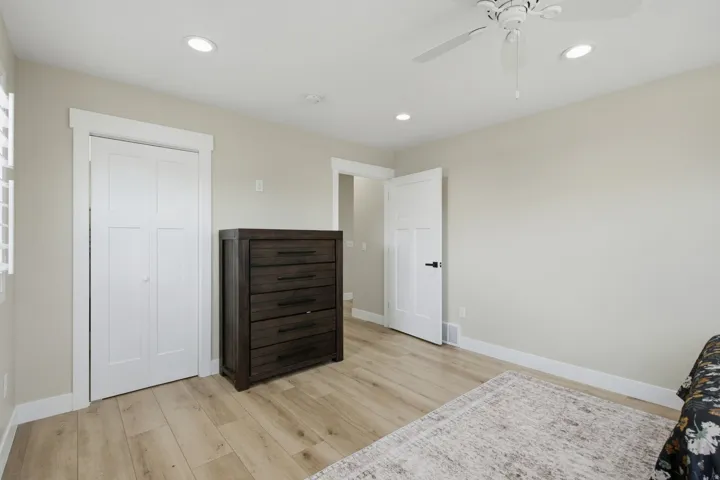 Recessed lighting, ceiling fan, wood-finish flooring, white trim, and white interior doors