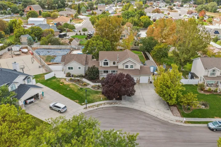 Expansive cul-de-sac lot featuring a two-story residence with an attached garage, paved driveway, and mature landscaping