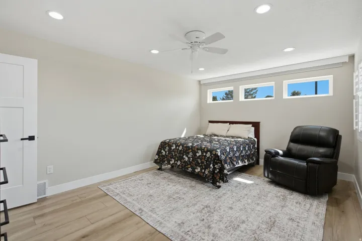 Recessed lighting, ceiling fan, three transom windows, wood-finish flooring, and a white interior door with black hardware