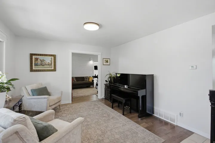Hardwood-style flooring throughout, light neutral wall color, and a flush-mount ceiling fixture