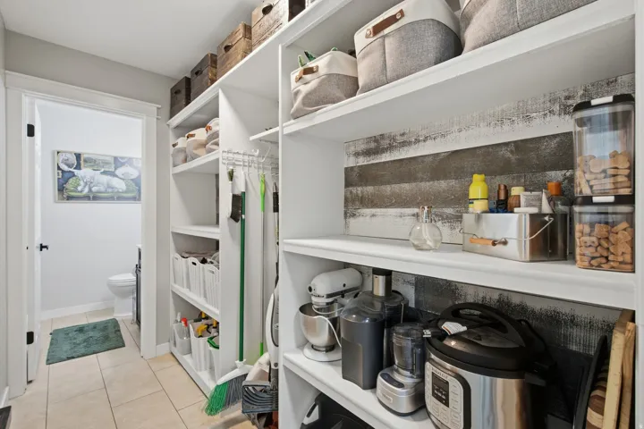 Built-in shelving with decorative paneling and tile flooring