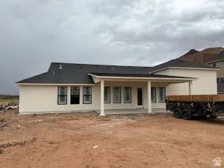 Exterior featuring a covered patio, multiple windows, and a dark shingle roof