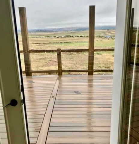 Expansive outdoor deck featuring wood-finish flooring and cable railings