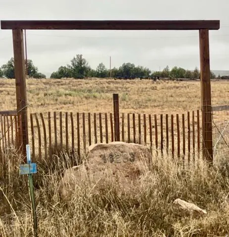 Wood-beam gateway with a stone address marker