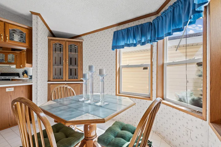 Built-in corner hutch with glass panel doors, adjacent to a dining area featuring a tiled tabletop