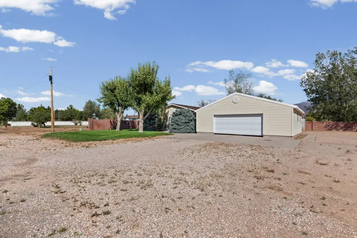 Detached garage with horizontal siding, two garage doors, and an arched vent