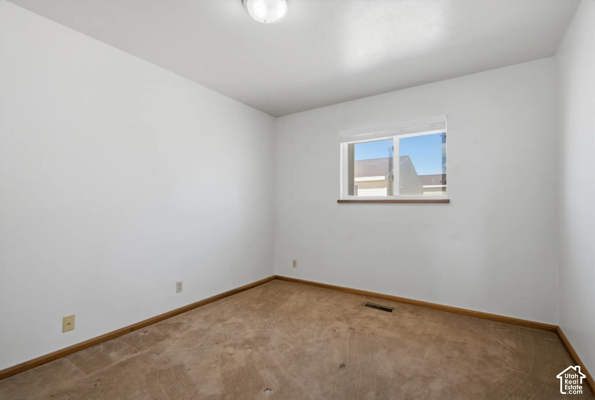 Recessed window with wood-finish sill, neutral wall color, and carpeted flooring