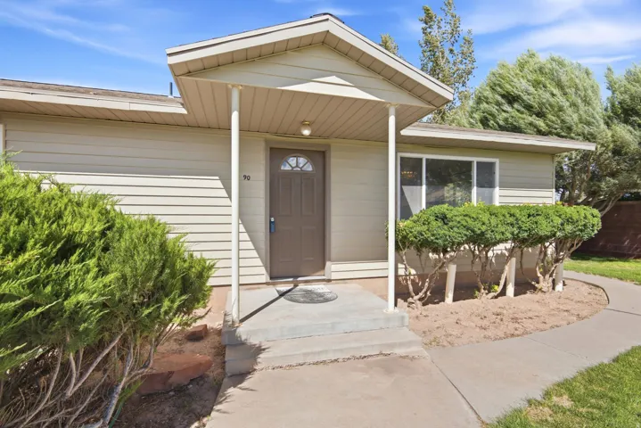 Covered front entry with concrete steps and walkway