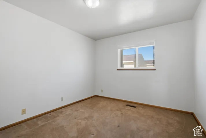 Recessed window with wood-finish sill, neutral wall color, and carpeted flooring