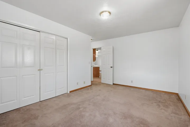 Neutral wall paint, carpeted flooring, and a flush mount ceiling light