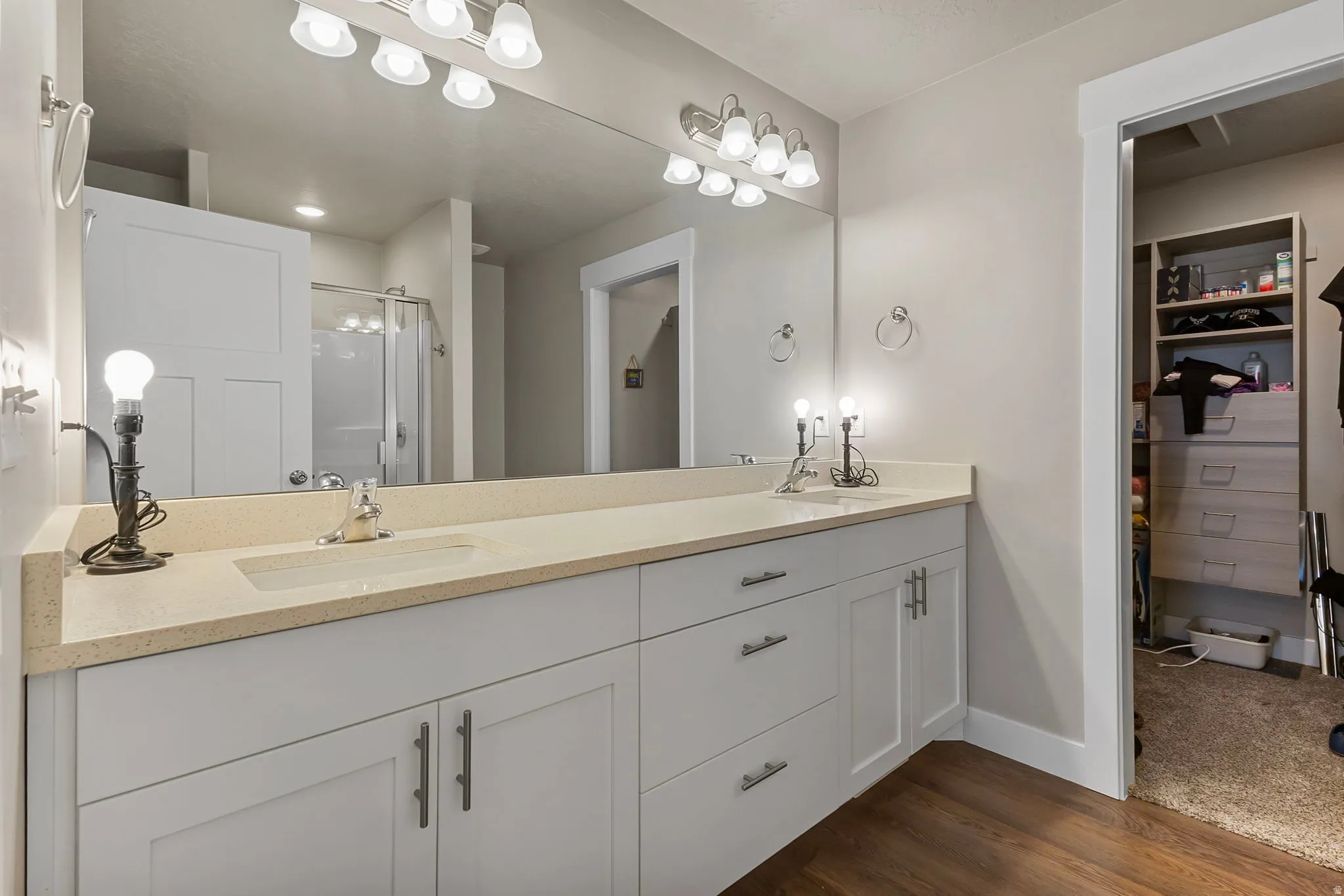 Double vanity with light-toned countertop, dual undermount sinks, and contemporary wall-mounted lighting