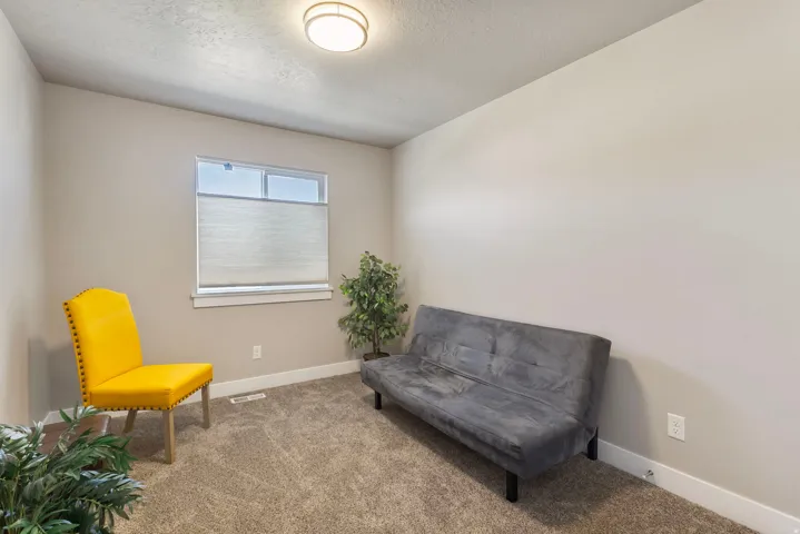 Wall-to-wall carpeting with neutral wall tones and a single window featuring a cellular shade