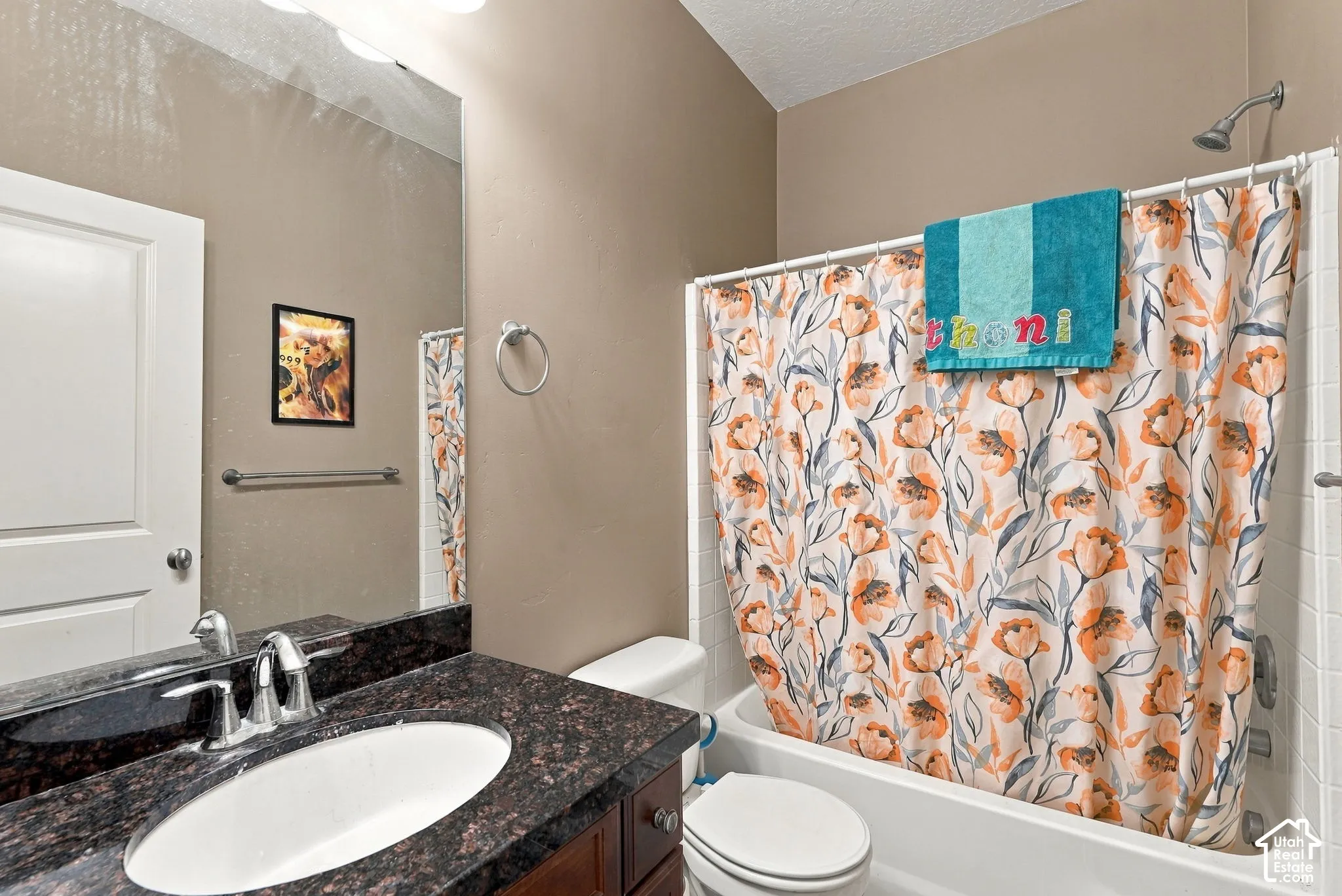 Bathroom with a dark wood-finish vanity, granite-look countertop, oval undermount sink, and a shower-over-tub combination