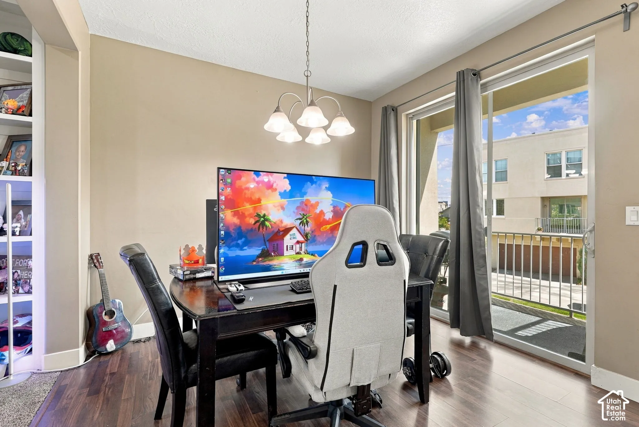 Wood-finish flooring, built-in shelving, chandelier lighting, and a sliding glass door with balcony access