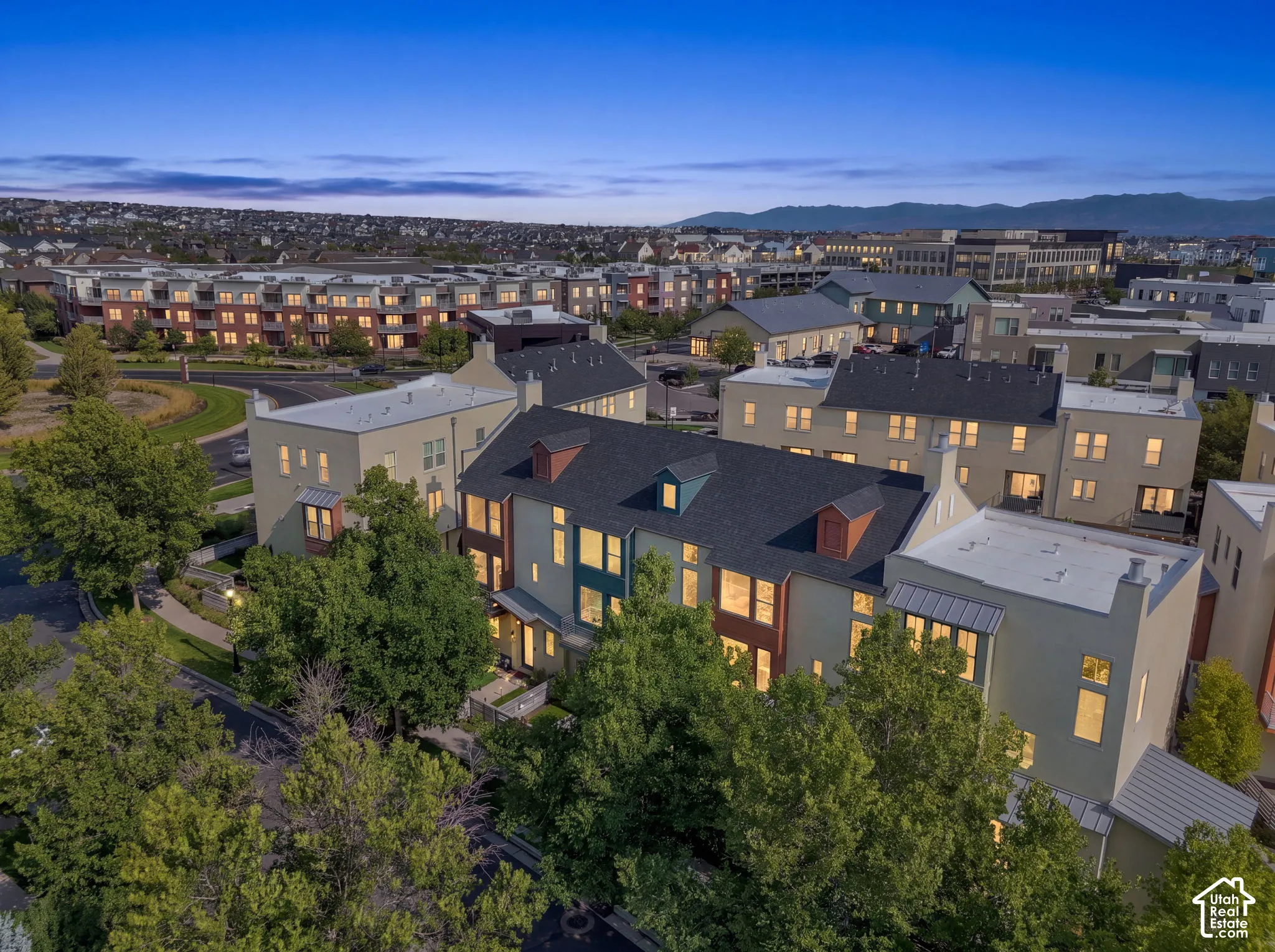 Multi-level townhome with a dark shingle roof, distinct dormer windows, and a varied facade
