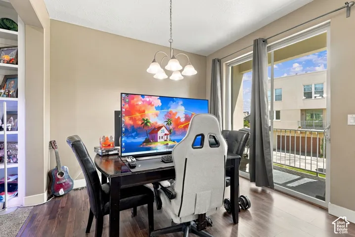 Wood-finish flooring, built-in shelving, chandelier lighting, and a sliding glass door with balcony access