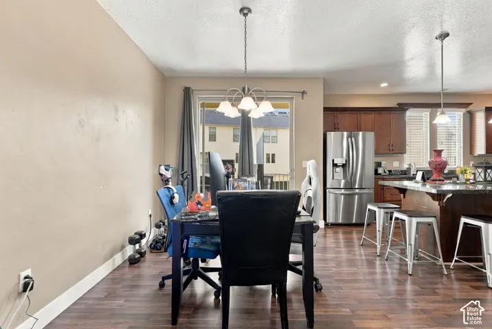 Wood-finish flooring throughout, stainless steel refrigerator, and dark wood cabinetry