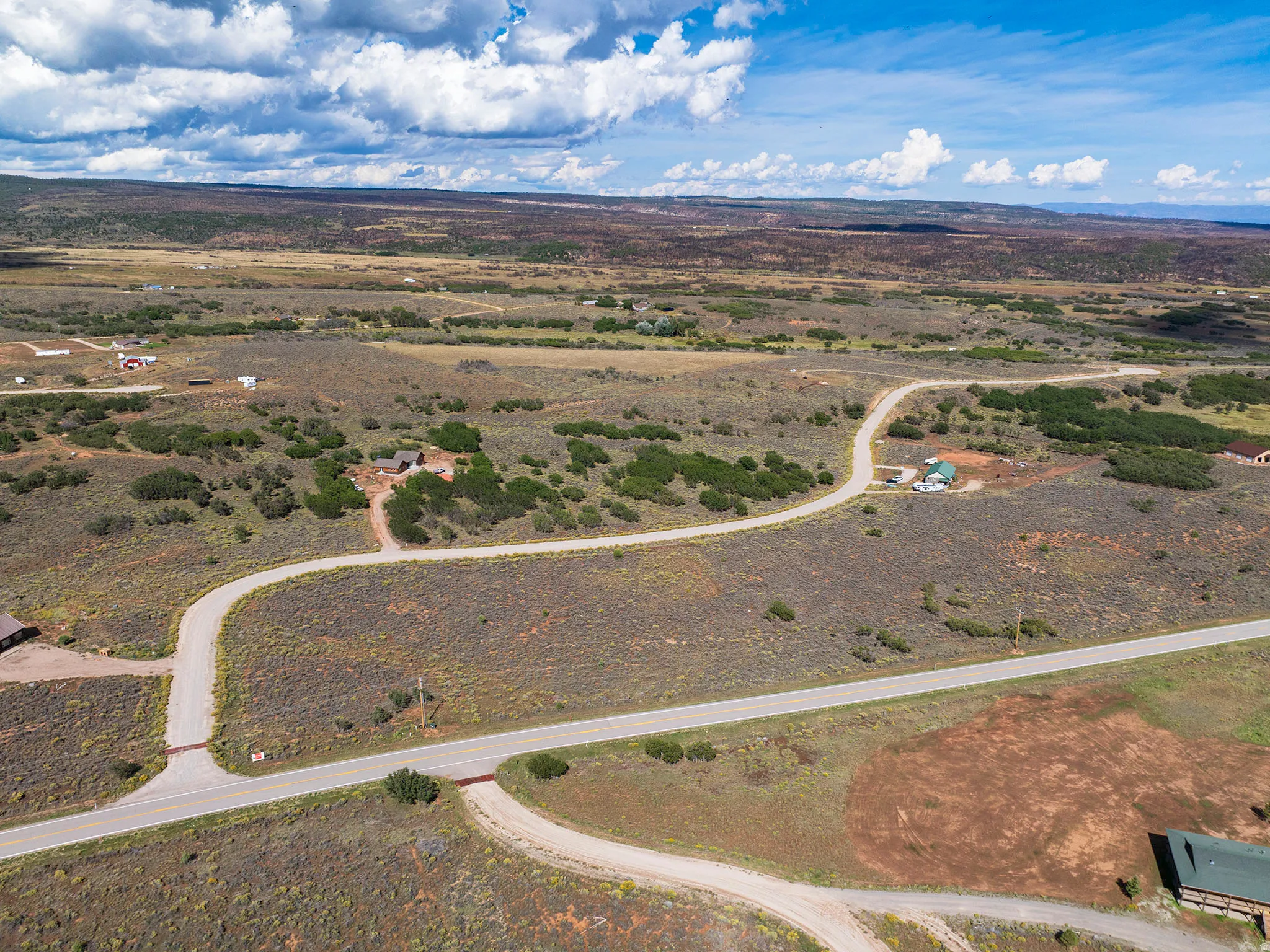 Extensive undeveloped land with multiple paved and unpaved roads, surrounded by natural vegetation
