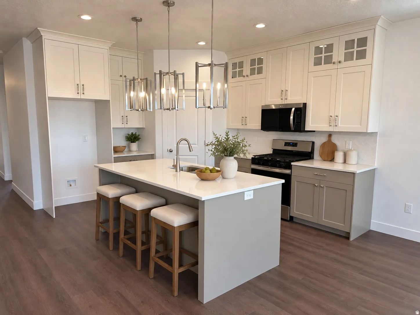 Kitchen featuring an island with countertop seating, stainless steel appliances, wood-finish flooring, white cabinetry, and recessed lighting