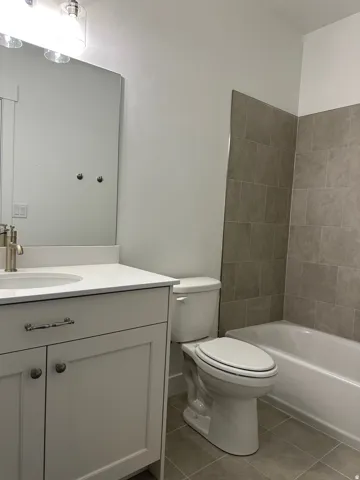 Bathroom featuring a single vanity with white cabinetry, a light-colored countertop, and a rectangular undermount sink