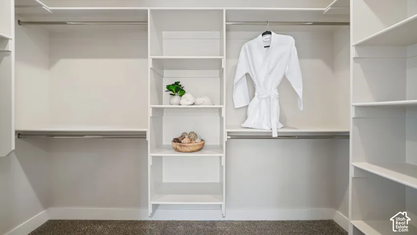 Integrated closet system with multiple shelving units, hanging rods, and light-toned walls