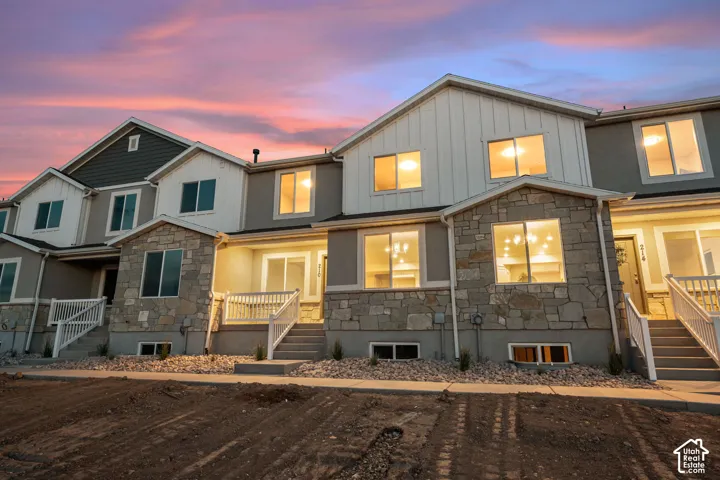 Multi-level townhome featuring stone and siding exterior accents