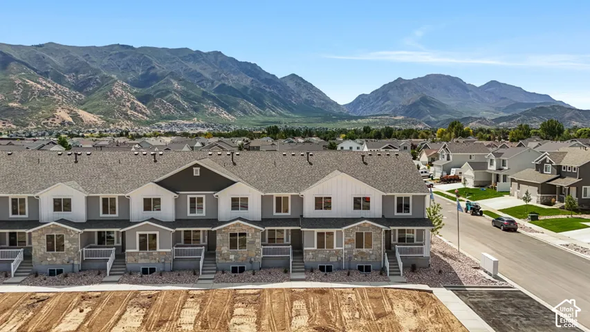 Townhome exteriors feature multi-level designs with stone veneer accents and covered entries