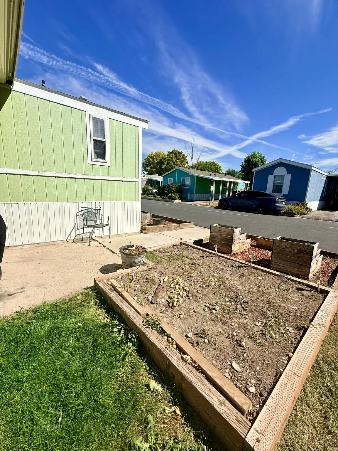 Exterior featuring vinyl siding, single-hung windows, and a raised garden bed