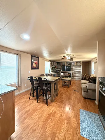 Open-concept living area featuring wood-finish flooring, recessed lighting, and a ceiling fan