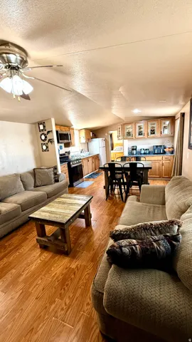 Wood-finish flooring throughout, ceiling fan with light fixture, natural wood cabinetry, and recessed lighting