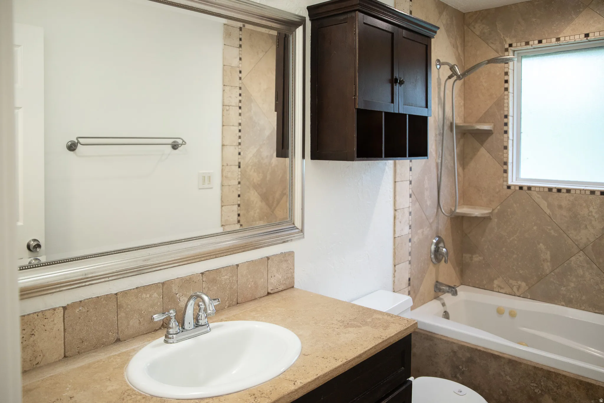Vanity with an integrated sink, polished chrome faucet, and stone countertop