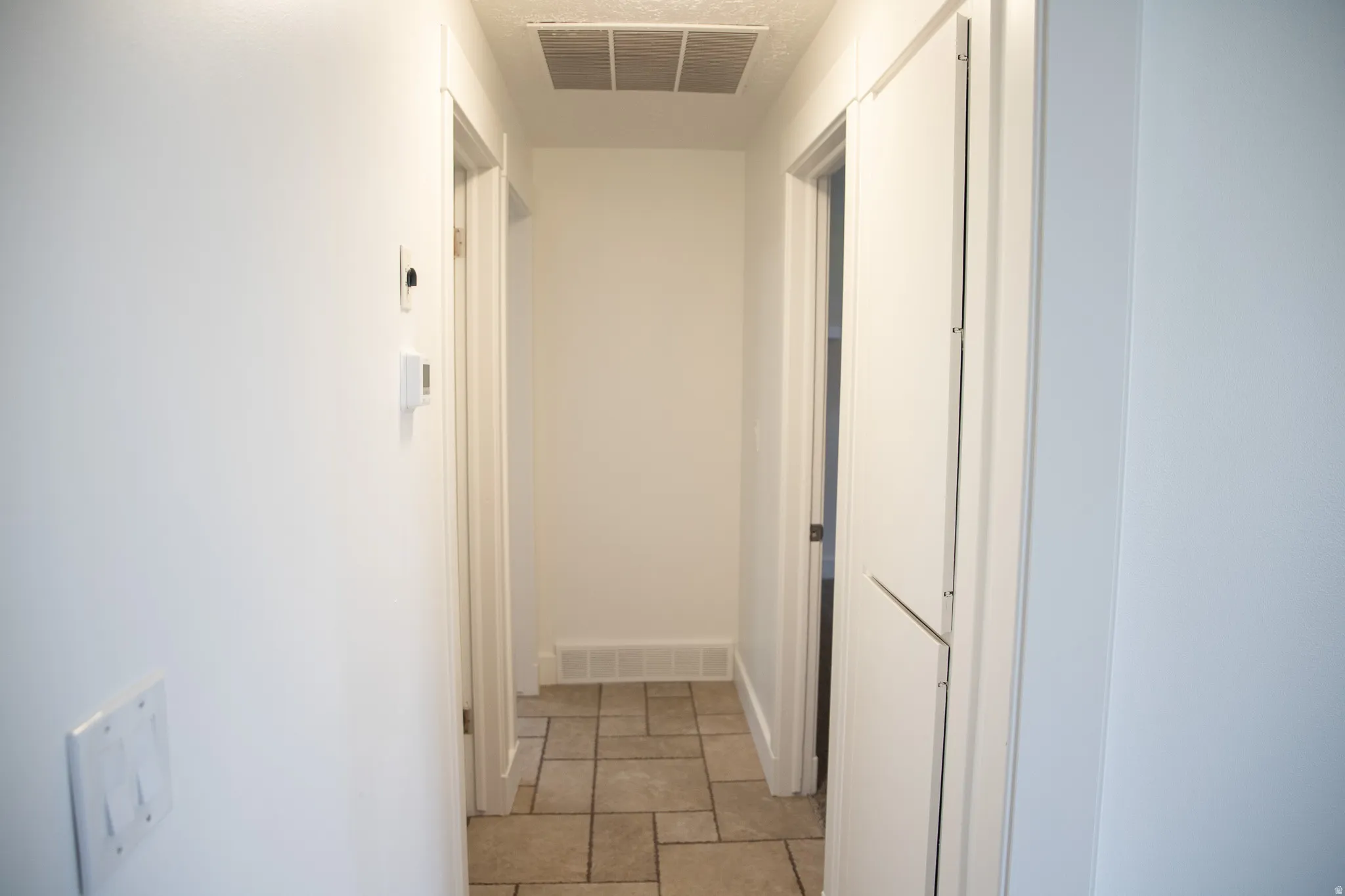 Light-toned tile flooring, white walls, and white trim