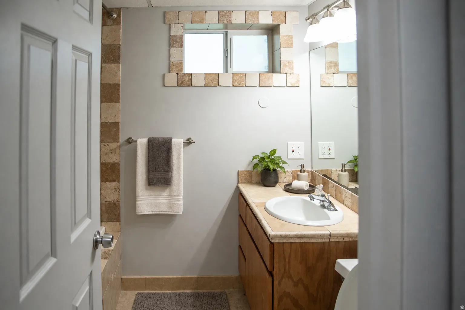 Vanity with an integrated sink, wood-finish cabinetry, and a countertop