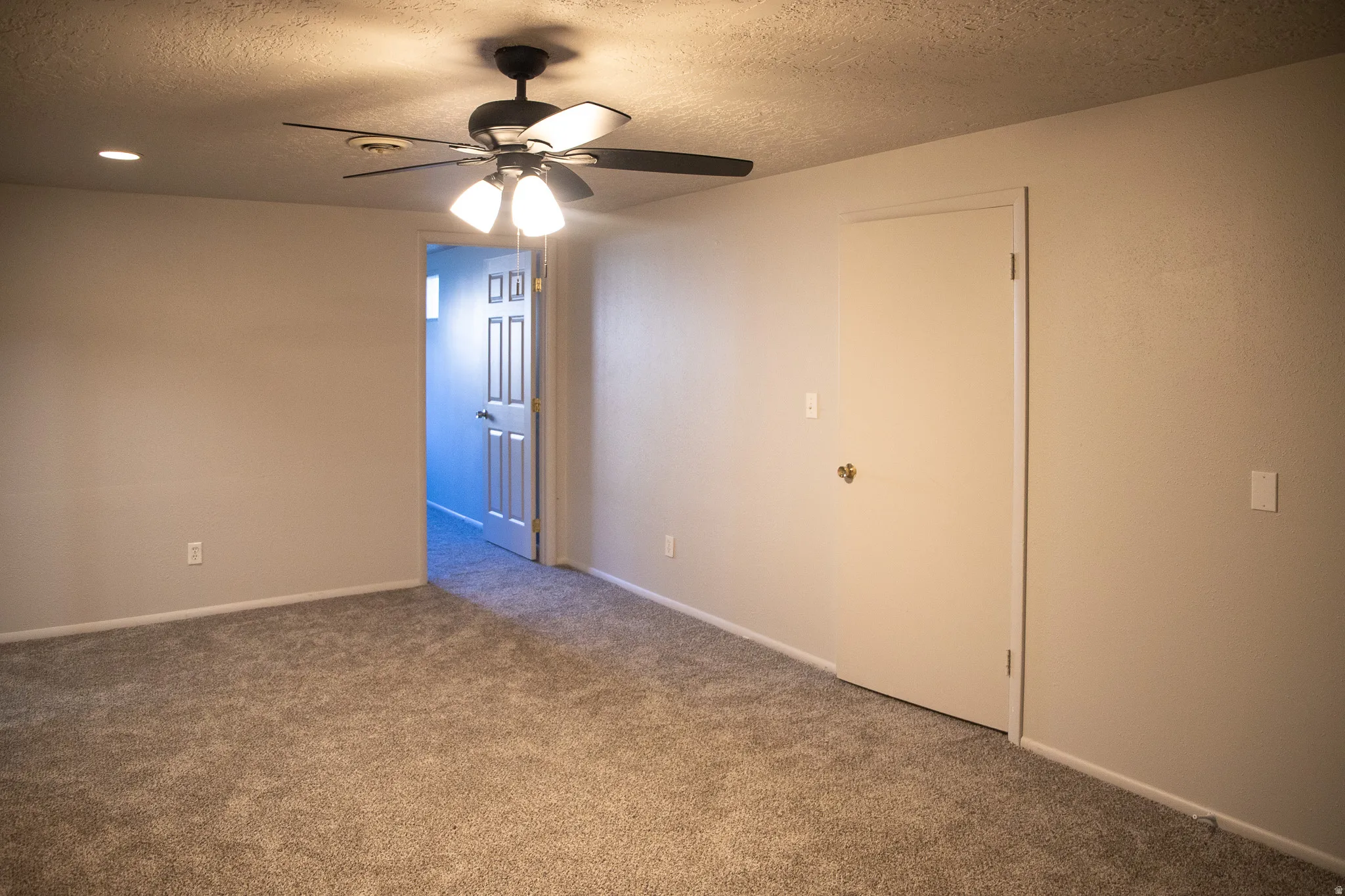 Neutral-toned walls with ceiling fan, recessed lighting, and carpeted flooring