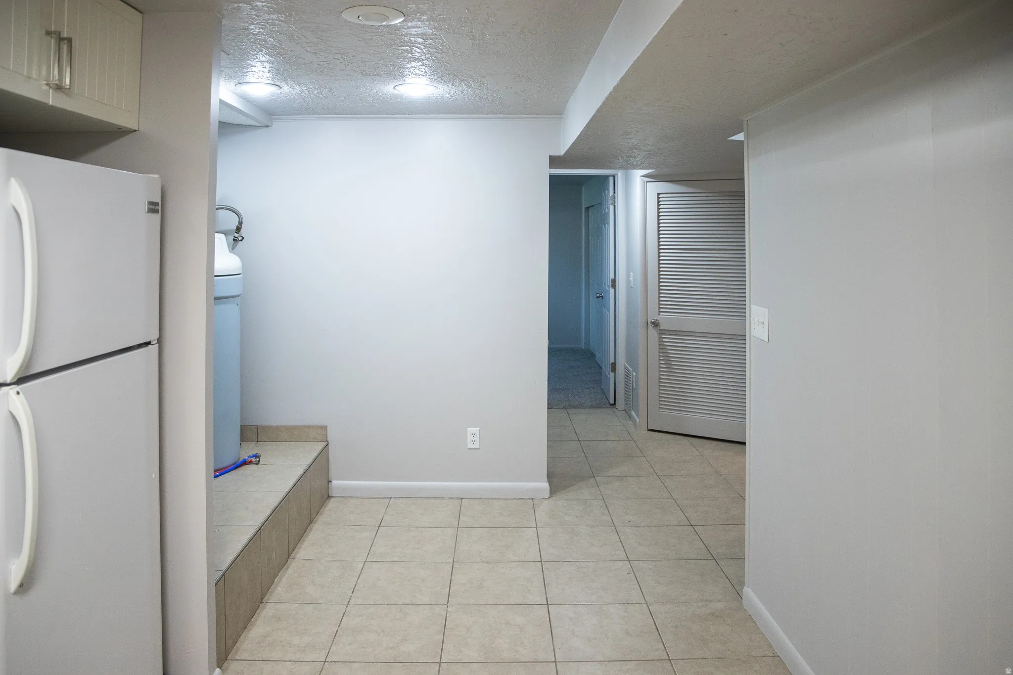 Recessed lighting illuminates tiled flooring