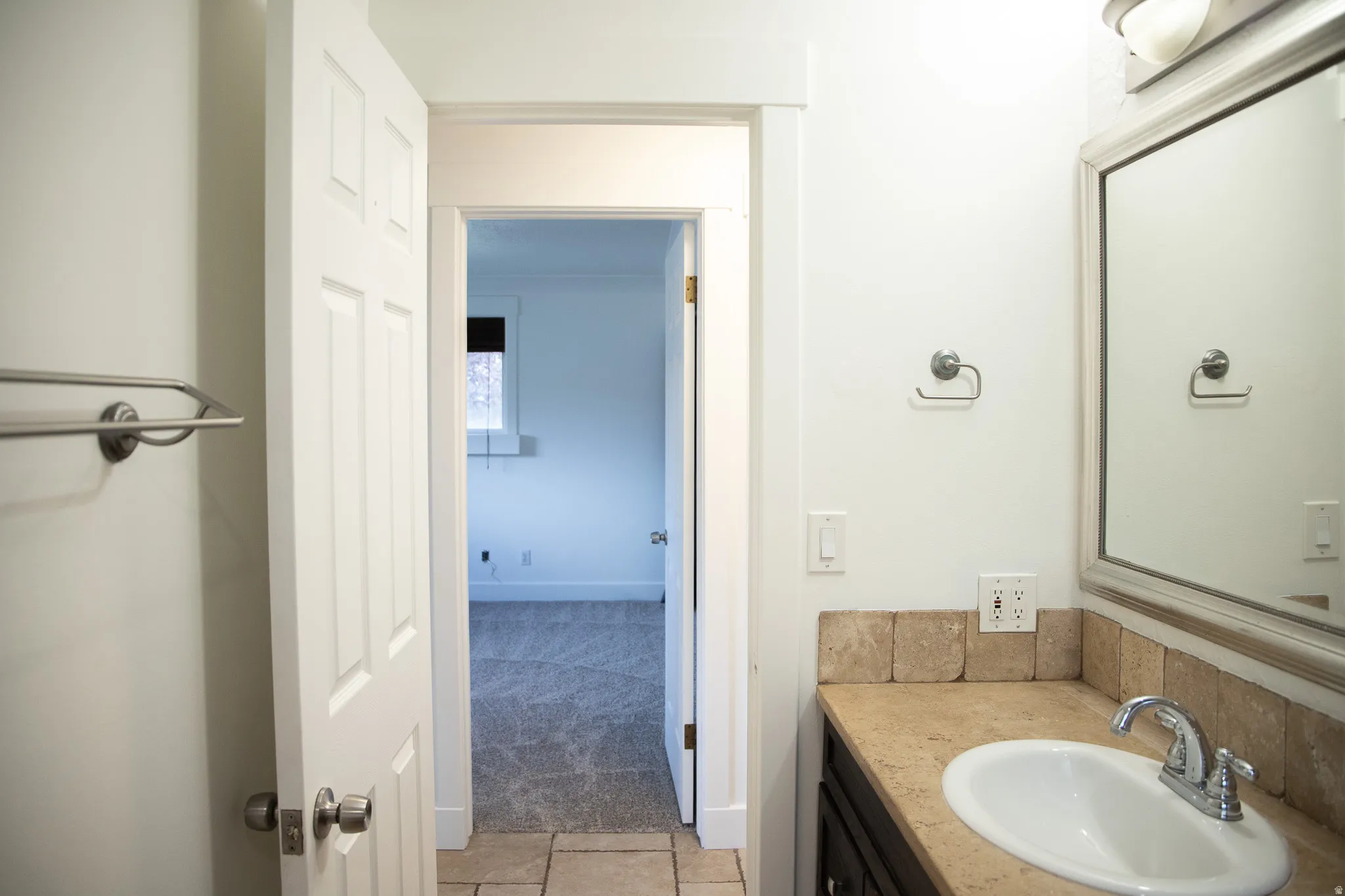 Vanity with an integrated sink, polished chrome faucet, and tiled backsplash