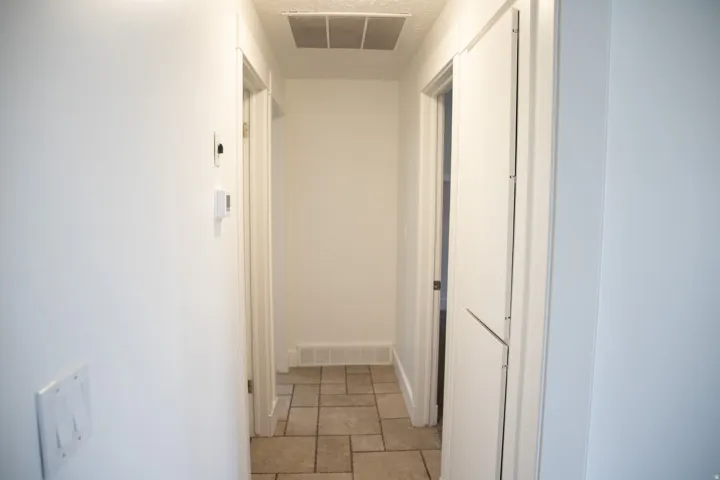 Light-toned tile flooring, white walls, and white trim