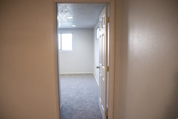 Room featuring neutral-toned carpeting, light-colored walls, recessed lighting, and a window for natural illumination