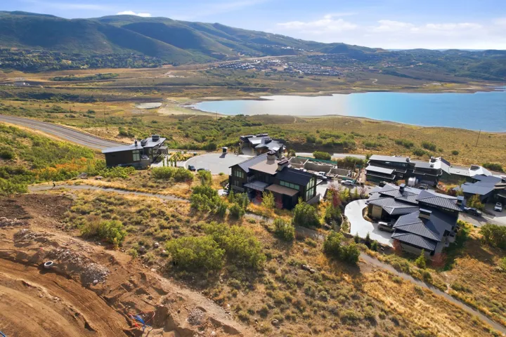 Dramatic hillside setting overlooking pristine alpine lake and mountain ranges