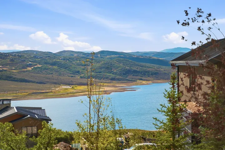 Waterfront property featuring expansive water frontage, mountainous terrain, and surrounding greenery